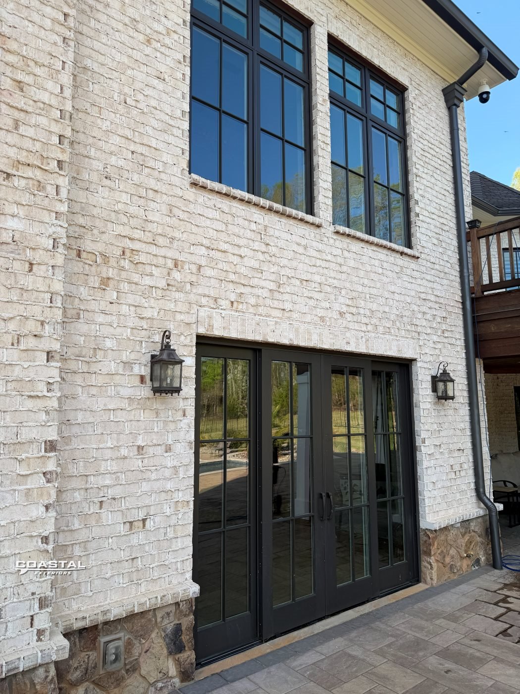 Second-story windows cleaned on a white-brick Charlotte home