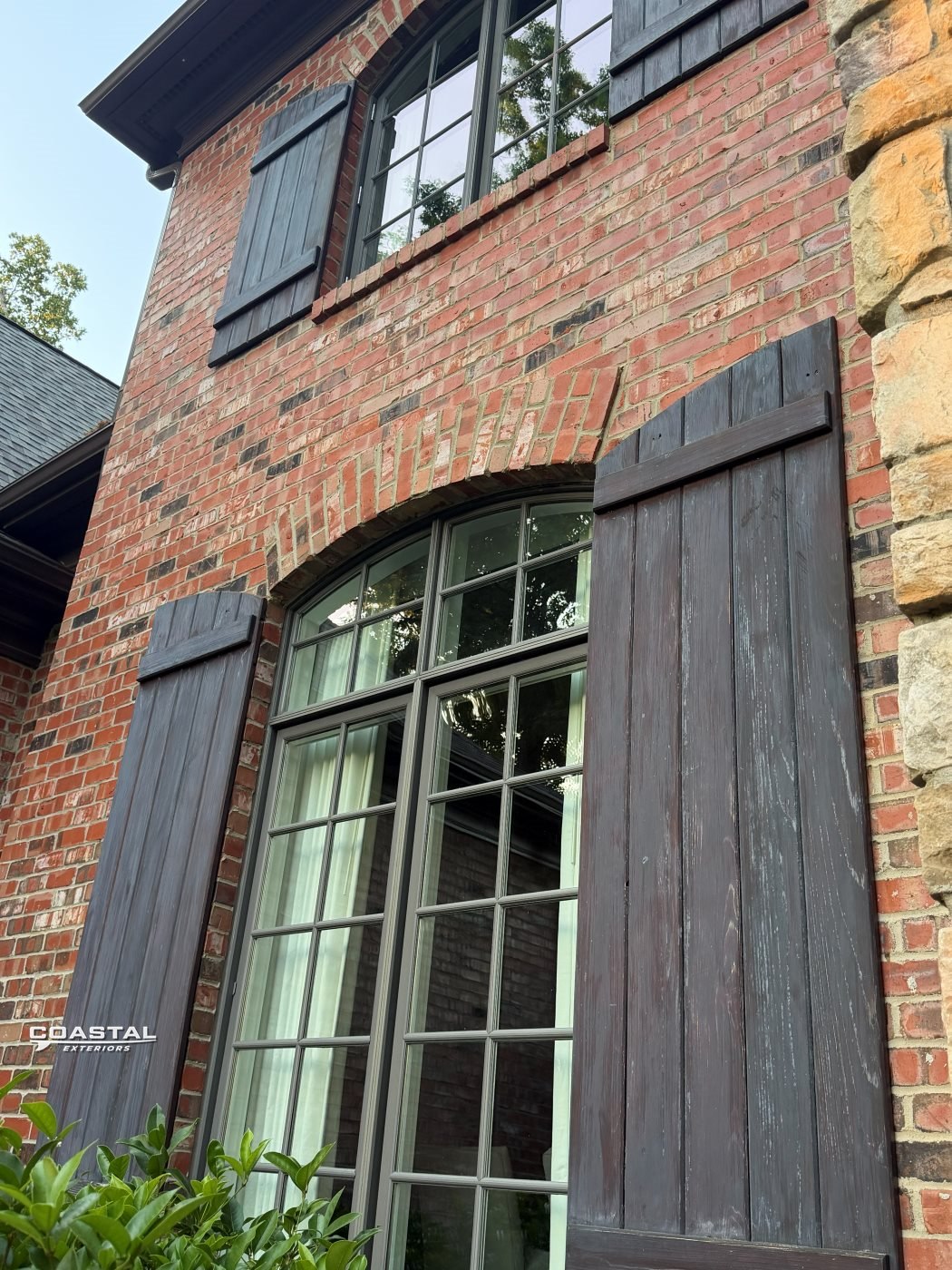 Tall arched windows cleaned on a brick home