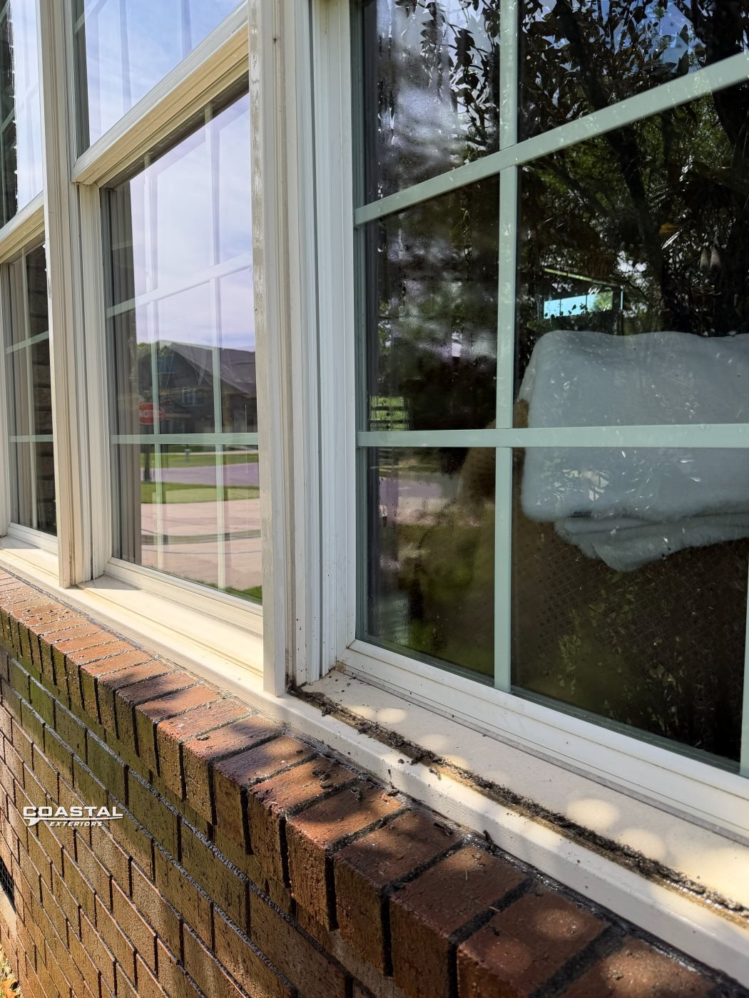 Exterior window cleaned above a brick ledge