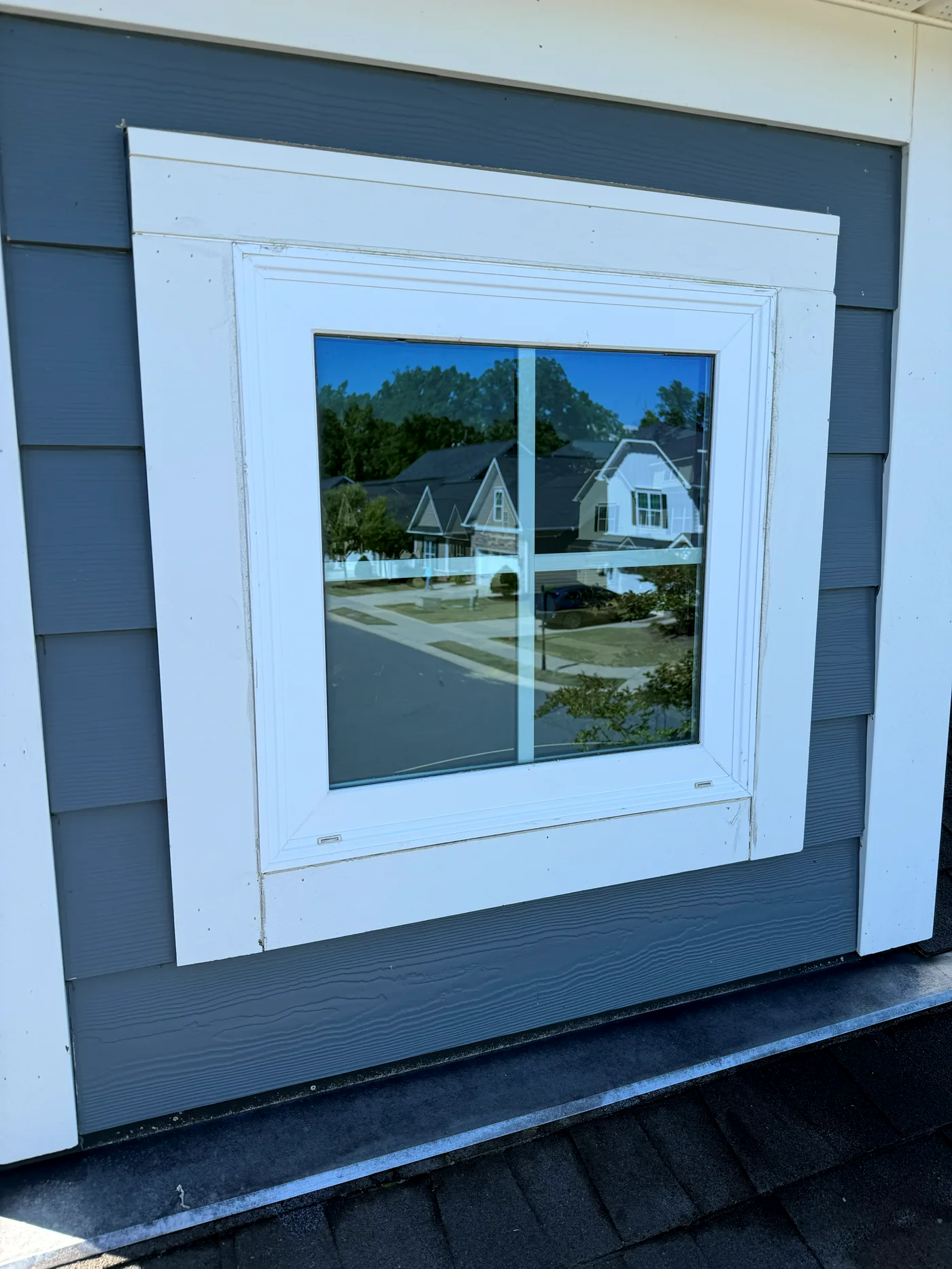 Window cleaned to a mirror-clear finish on a gray-sided home