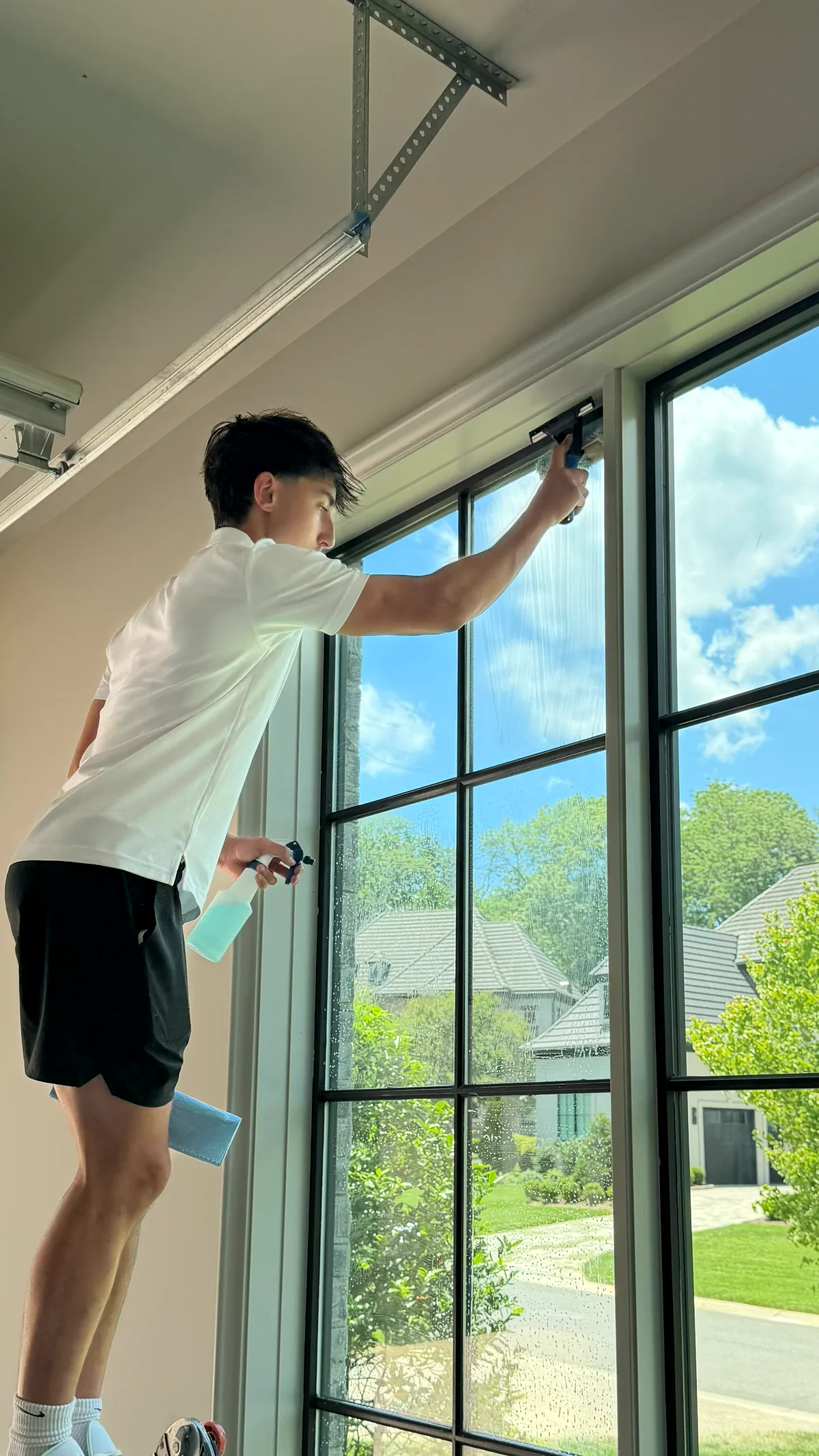 Technician squeegeeing an interior window pane to a streak-free finish
